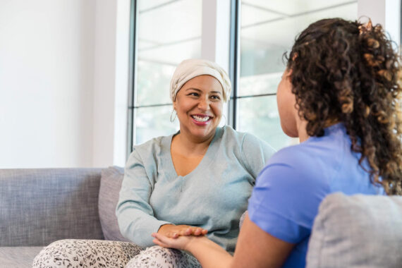 Female hospice patient smiles at her visiting nurse